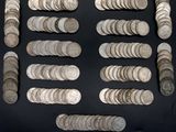 some silver coins are arranged in a row on a black surface