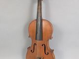 an old violin sitting on top of a table next to a wall