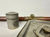 a metal container and a metal pipe on a white surface
