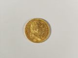 a close up of a gold coin on a white surface