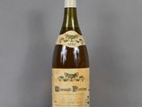 an old bottle of wine sitting on top of a table
