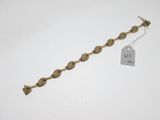 un bracelet en or sur fond blanc, avec une étiquette de prix
