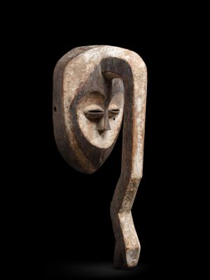 une image représentant une sculpture en bois représentant un visage sur fond noir