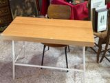une table avec une chaise et un tableau accroché au mur