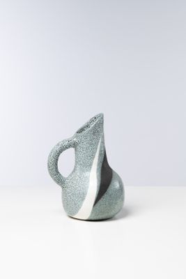 vase en céramique gris et blanc posé sur une surface blanche, sur fond blanc