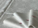 deux serviettes pliées posées sur un lit recouvert d'une couette blanche
