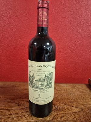 a bottle of red wine sitting on a wooden table