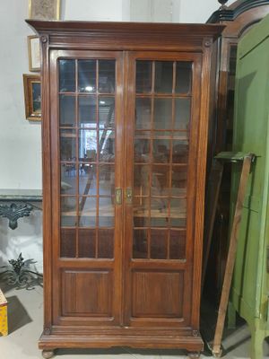 un grand meuble en bois avec des portes en verre dans une pièce