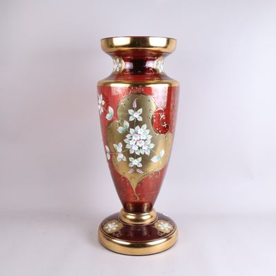 a red vase with a gold base on a white background