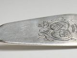 silver spoon with a metal handle with a design on it