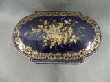 an image of a blue and gold box with flowers on it