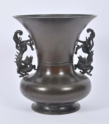 un vase en métal orné d'une poignée en forme de dragon sur fond blanc