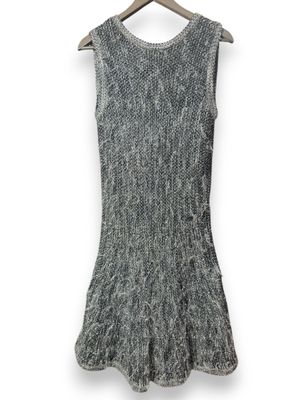 une robe en tricot grise suspendue à un cintre en bois