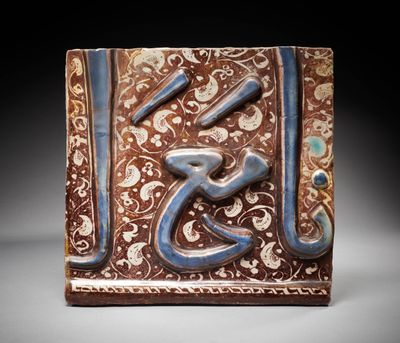 une image représentant un carreau décoratif orné de calligraphie arabe