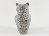 a silver owl figurine sitting on a white surface