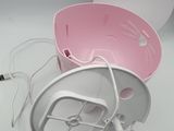 a pink and white bowl with a power cord attached to it