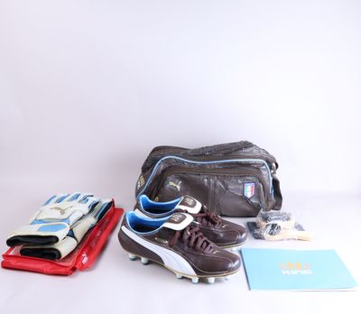 un sac, une paire de chaussures, un livre et d'autres objets disposés sur une surface blanche