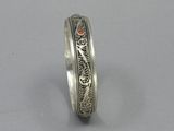 a close up of a silver ring with an orange stone in the center