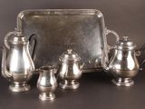 a silver tray with a silver tea set on it