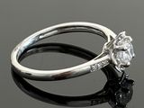 a close up of a diamond ring on a black surface