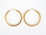 deux paires de boucles d'oreilles en or sur fond blanc