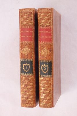deux vieux livres posés l'un sur l'autre sur une surface blanche