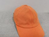 an orange baseball cap sitting on top of a gray surface