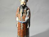 une image représentant une figurine d'un homme portant un chapeau et une robe