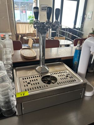 Des bouteilles d'eau sont alignées sur le comptoir d'un café.
