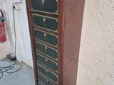 a tall wooden cabinet with many drawers on it
