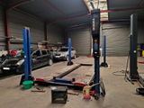 a car that is parked in a garage with a lift