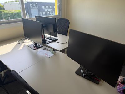 a desk with two monitors and a laptop on it