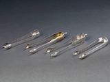 six cuillères en argent et deux cuillères en argent posées sur une surface grise