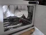 a microwave with towels in it and a basket in front of it