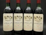 quatre bouteilles de vin sont alignées sur une surface noire