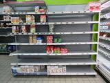 many empty shelves in a grocery store with food on them