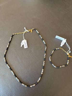 deux colliers et des bracelets posés sur une table, accompagnés d'étiquettes