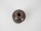a small brown vase sitting on a white surface