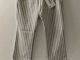 un pantalon rayé blanc et gris suspendu à un cintre