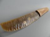 a large knife that is on a plate on a table