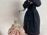 three figurines of women dressed in black and pink dresses