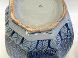 a blue and white vase with a gold rim on it