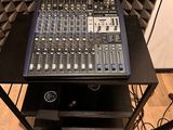 a sound board sitting on top of a table in front of a sound booth