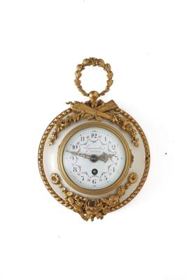 une horloge en or accrochée au mur, entourée d'une corde