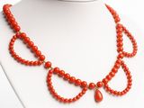 an image of a necklace made of coral beads with a gold clasp