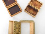 three small wooden boxes sitting on top of each other on a white surface