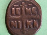 an old coin with a cross on it on a green surface