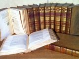 Plusieurs vieux livres sont empilés les uns à côté des autres sur une table en bois.