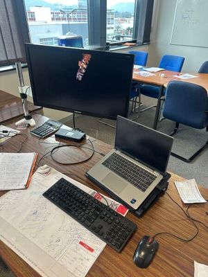 un bureau sur lequel se trouvent un ordinateur portable, un clavier, une souris et d'autres objets