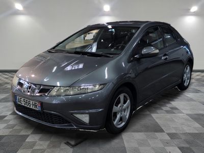 La Honda Civic grise est garée dans le garage, sur un sol à damier.